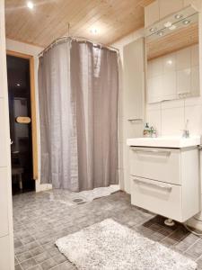 a bathroom with a shower curtain and a sink at Avara, ylellinen kaksikerroksinen huoneisto. in Jyväskylä