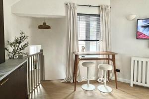 a kitchen with a table and stools in a room at No.1 Lighthouse Dawlish Beach in Dawlish