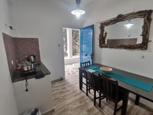 a dining room with a table and chairs and a mirror at VILLA VASILIS ORNOS in Mýkonos City