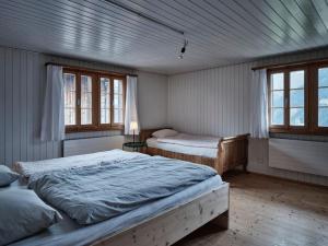 een slaapkamer met 2 bedden en 2 ramen bij Cosy traditional mountain house in scenic valley in Cumbels