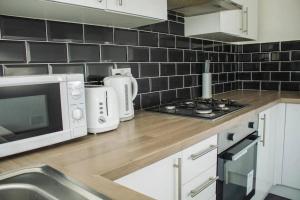 a kitchen with a counter top with a microwave and appliances at Charming 4BR House in Liverpool FC in Liverpool