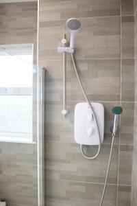 a shower with a shower head in a bathroom at Charming 4BR House in Liverpool FC in Liverpool