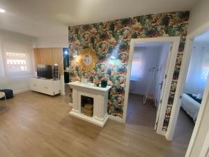 a living room with a fireplace and a floral wall at Isabella Center Boutique in Toledo
