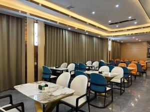 XI AN JIU DIAN Hotel في سيهانوكفيل: غرفة طعام مع طاولات وكراسي وستائر