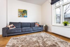 a living room with a couch and a window at Cozy home in the city center- contactless self check in in Tallinn
