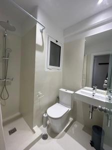 a white bathroom with a toilet and a sink at Platon Hotel in Piraeus
