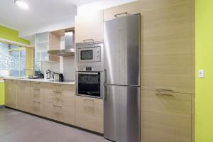 a large kitchen with a stainless steel refrigerator at Con parking gratis en el centro by CABANA Rentals in Vigo