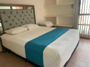 1 dormitorio con 1 cama grande con manta azul y blanca en A 3 cuadras de la playa DPTO c/ Alberca en Boca del Río