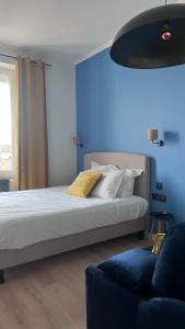 1 dormitorio con cama y pared azul en Hôtel 2 étoiles et Restaurant Le Galet Bleu, en Fouras