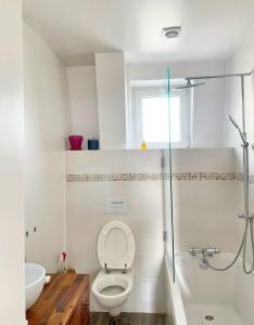 ein weißes Badezimmer mit Toilette und Dusche in der Unterkunft 3P cosy et lumineux proche de La Défense et Paris in La Garenne-Colombes