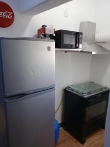 eine Küche mit einem Kühlschrank und einer Mikrowelle in der Unterkunft Casa Bruniel in Montevideo