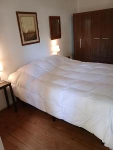 uma grande cama branca num quarto com 2 candeeiros em Casa Bruniel em Montevidéu