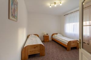 two twin beds in a room with a window at Déli Terasz C Apartman Free parking, self-check-in anytime in Győr