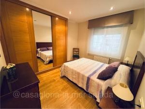 a bedroom with a bed and a large mirror at CASA GLORIA - LA MAR SALADA in Combarro