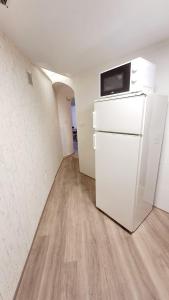 - un réfrigérateur blanc dans une pièce vide dotée de parquet dans l'établissement La casita del arco, à Santa Cruz de la Zarza