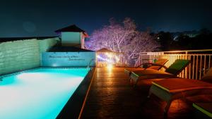 a swimming pool at night with blue lights at 360 Bliss Dia Hotels in Nerul