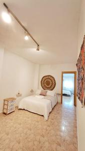 - une chambre blanche avec un lit et un miroir dans l'établissement La casita del arco, à Santa Cruz de la Zarza