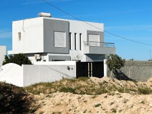 una casa blanca sentada en la cima de una colina en Villa privé 4 chambres 4 lit double à Djerba en face de la ferme de lotos, en Midoun