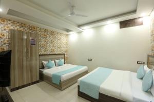 Habitación de hotel con 2 camas y almohadas azules en Hotel Amenda Delhi IGI Airport International Mahipalpur, en Nueva Delhi
