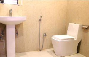 y baño con aseo y lavamanos. en Hotel Amenda Delhi IGI Airport International Mahipalpur, en Nueva Delhi