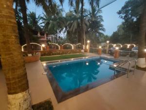 - une piscine dans une cour avec un palmier dans l'établissement Palm Bliss by Palmeraie Holidays, à Alibaug