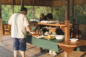 a group of people standing around a table with a tray of food at Amazon Arowana Lodge in Sao Pedro
