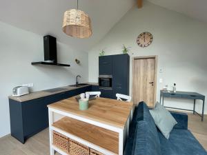 eine Küche und ein Wohnzimmer mit einem Sofa und einem Tisch in der Unterkunft La Grange d'Haversin in Ciney