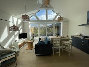 ein Wohnzimmer mit einem blauen Sofa und einer Küche in der Unterkunft La Grange d'Haversin in Ciney