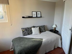 a bedroom with a bed and a shelf on the wall at Sur le Pont in Vaison-la-Romaine