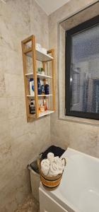 La salle de bains est pourvue d'un lavabo et d'un panier de serviettes. dans l'établissement Iaki Apartment Mamaia, à Mamaia