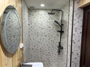 a bathroom with a shower with a sink and a mirror at Cozy Wooden House in Kiket'i კიკეთი in Kiketʼi