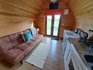 uma sala de estar com um sofá numa cabana de madeira em Robin- Ensuite Glamping Pod em Truro