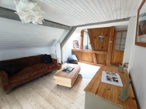 ein Wohnzimmer mit einem Sofa und einem Tisch in der Unterkunft Charmant meublé classé 3 étoiles dans ferme du XIXe restaurée in Le Hohwald