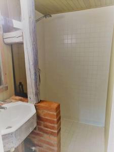 ein Badezimmer mit einem Waschbecken und einer Ziegelwand in der Unterkunft Charmant meublé classé 3 étoiles dans ferme du XIXe restaurée in Le Hohwald