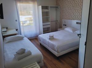 um quarto com 2 camas e uma janela em Hotel Restaurant Les Chataigniers em Privas