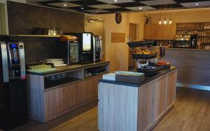 a coffee shop with a counter with food on it at Hotel Restaurant Les Chataigniers in Privas