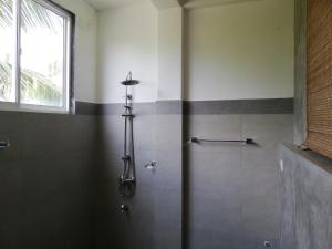 a shower stall in a bathroom with a window at VILLA MAANE by GOODWILL in Hikkaduwa