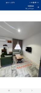 un soggiorno con un divano e un tavolo di Studio overlooking pool amid flowering and quiet a Al Ula