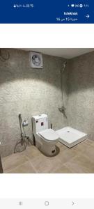 a bathroom with a white toilet in a room at Studio overlooking pool amid flowering and quiet in Al-ʿUla +27 photos