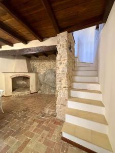 uma escada num quarto com uma lareira de pedra em Maison Camilla Casa vacanze em Monte San Biagio