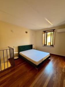 um quarto com uma cama grande e piso em madeira em Maison Camilla Casa vacanze em Monte San Biagio