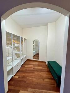 um quarto com prateleiras brancas e um sofá verde em Maison Camilla Casa vacanze em Monte San Biagio