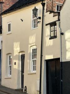 un bâtiment blanc avec une porte noire dans une rue dans l'établissement The Nook Lincoln, à Lincolnshire