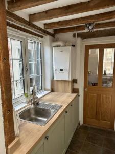 - une cuisine avec un évier et un comptoir avec une fenêtre dans l'établissement The Nook Lincoln, à Lincolnshire