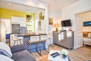 a living room with a couch and a kitchen at La Maison de Pêcheur de Ginette in Cabourg +8 photos