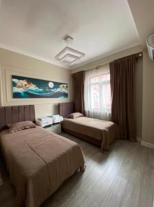 ein Hotelzimmer mit 2 Betten und einem Fenster in der Unterkunft Ali假日民宿 in Almaty