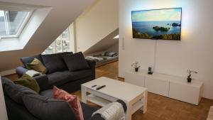 een woonkamer met een bank en een tv aan de muur bij Ferienwohnung Rhein-Panorama in Lahnstein