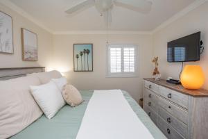 a bedroom with a bed with a television and a dresser at Waters Edge in Myrtle Beach