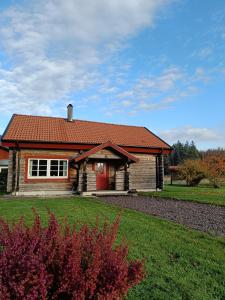 uma casa com um telhado vermelho e um quintal em Fårgården Åsebol em Gårdsjö