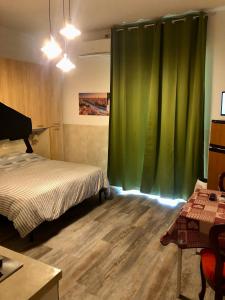ヴェローナにあるAppartamento Veronaのベッドルーム(ベッド1台、緑のカーテン付)